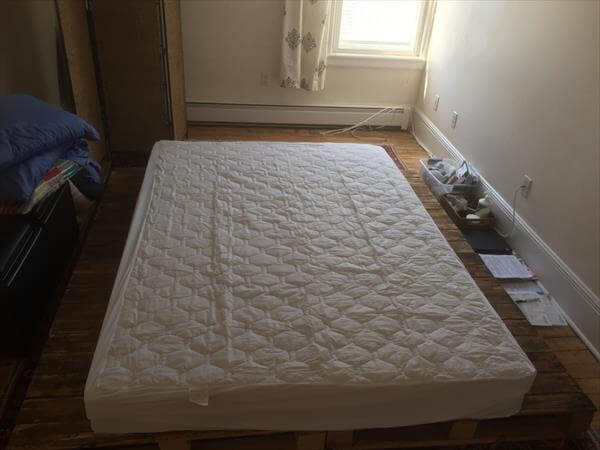 repurposed pallet platform bed with white mattress